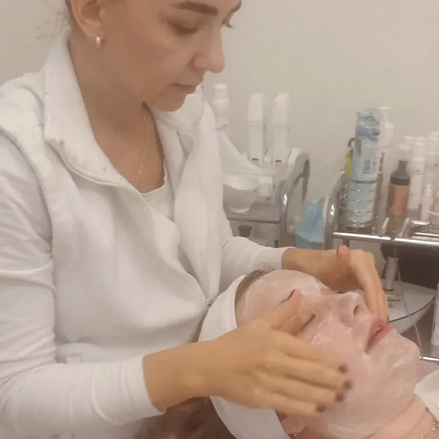 Mgr. Zuzana Machovičová nanáša klientke pleťovú masku